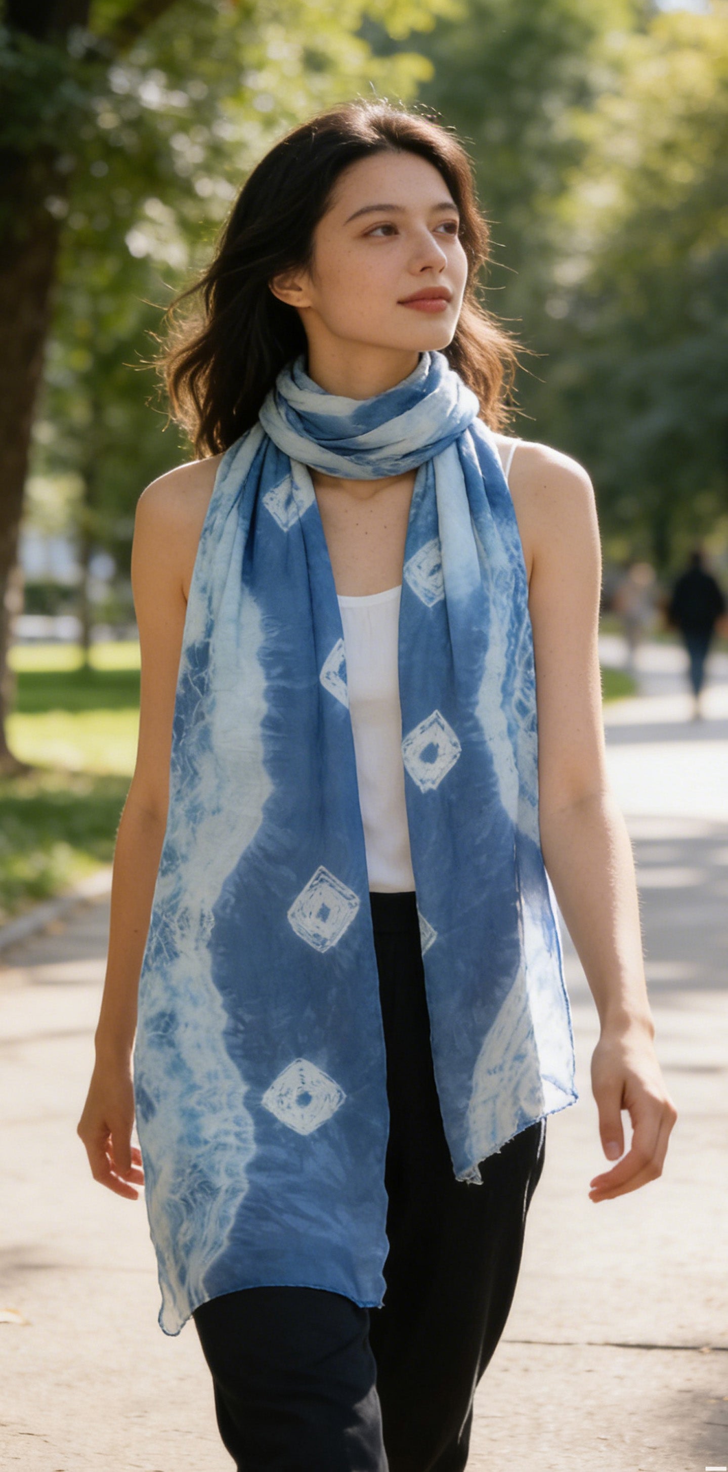 Woman wearing a blue patterned scarf in an outdoor setting