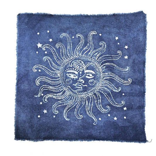 A square blue textile or rug with a white hand-drawn style sun face, radiating rays, and small stars, shown flat against a white background.