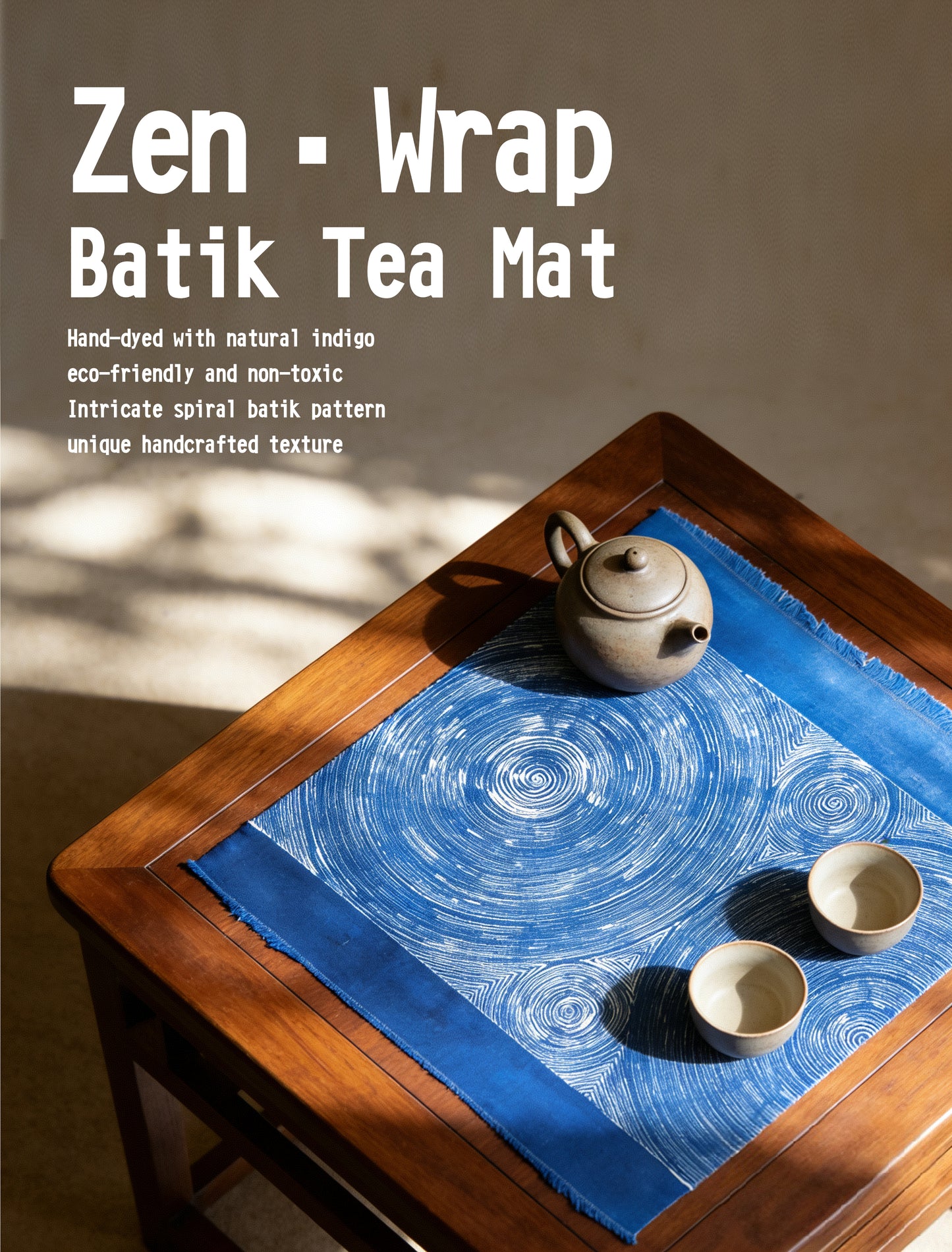 Blue batik tea mat on a wooden table with teapot and cups, labeled 'Zen Wrap Batik Tea Mat'.