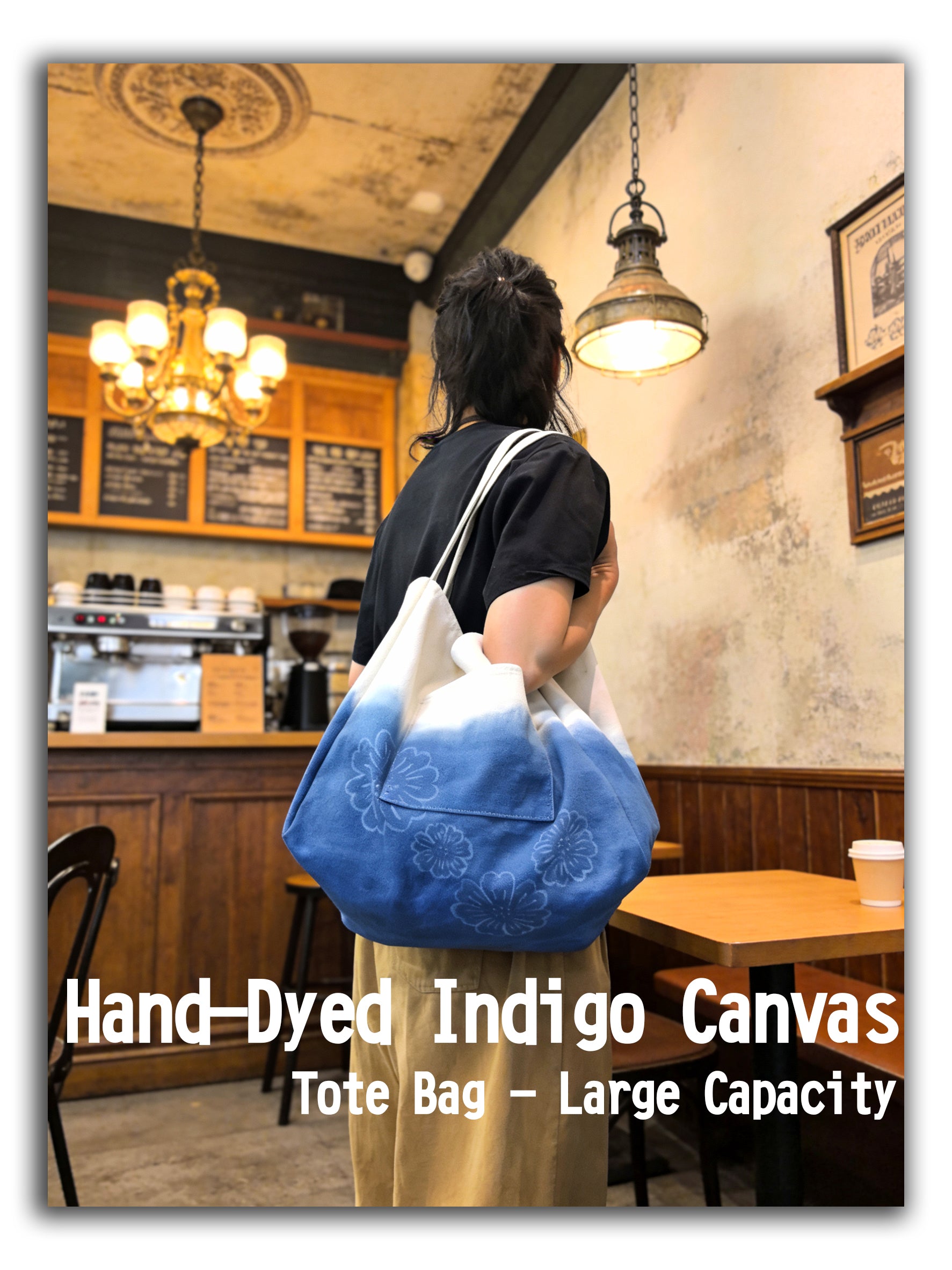 Person holding a blue hand-dyed indigo canvas tote bag in a cafe setting