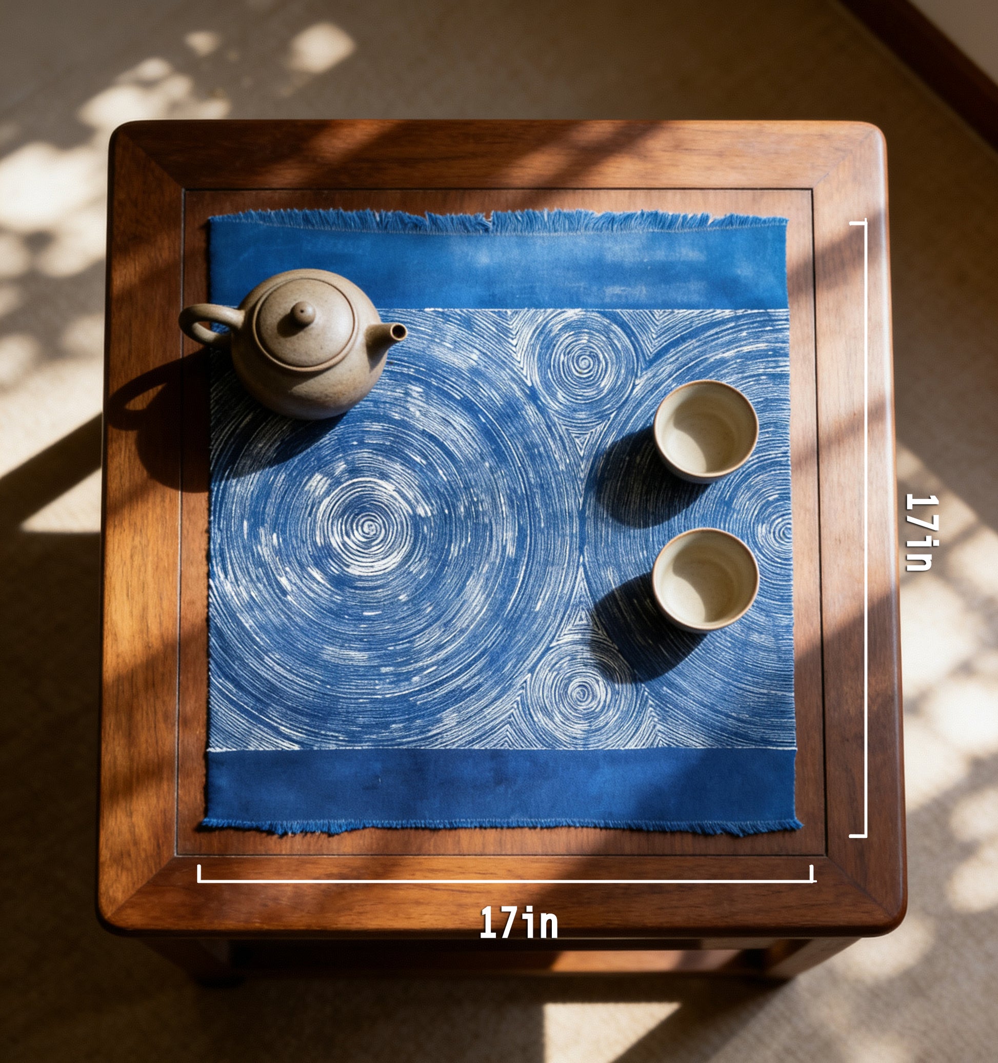 Tea set on a blue patterned cloth with measurements on a wooden table