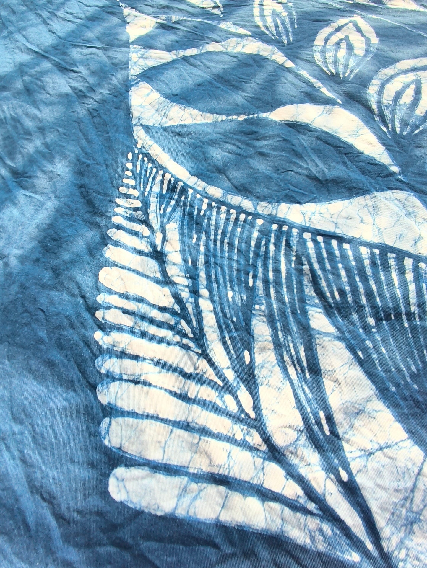 Close-up of a blue and white patterned fabric with leaf-like shapes.