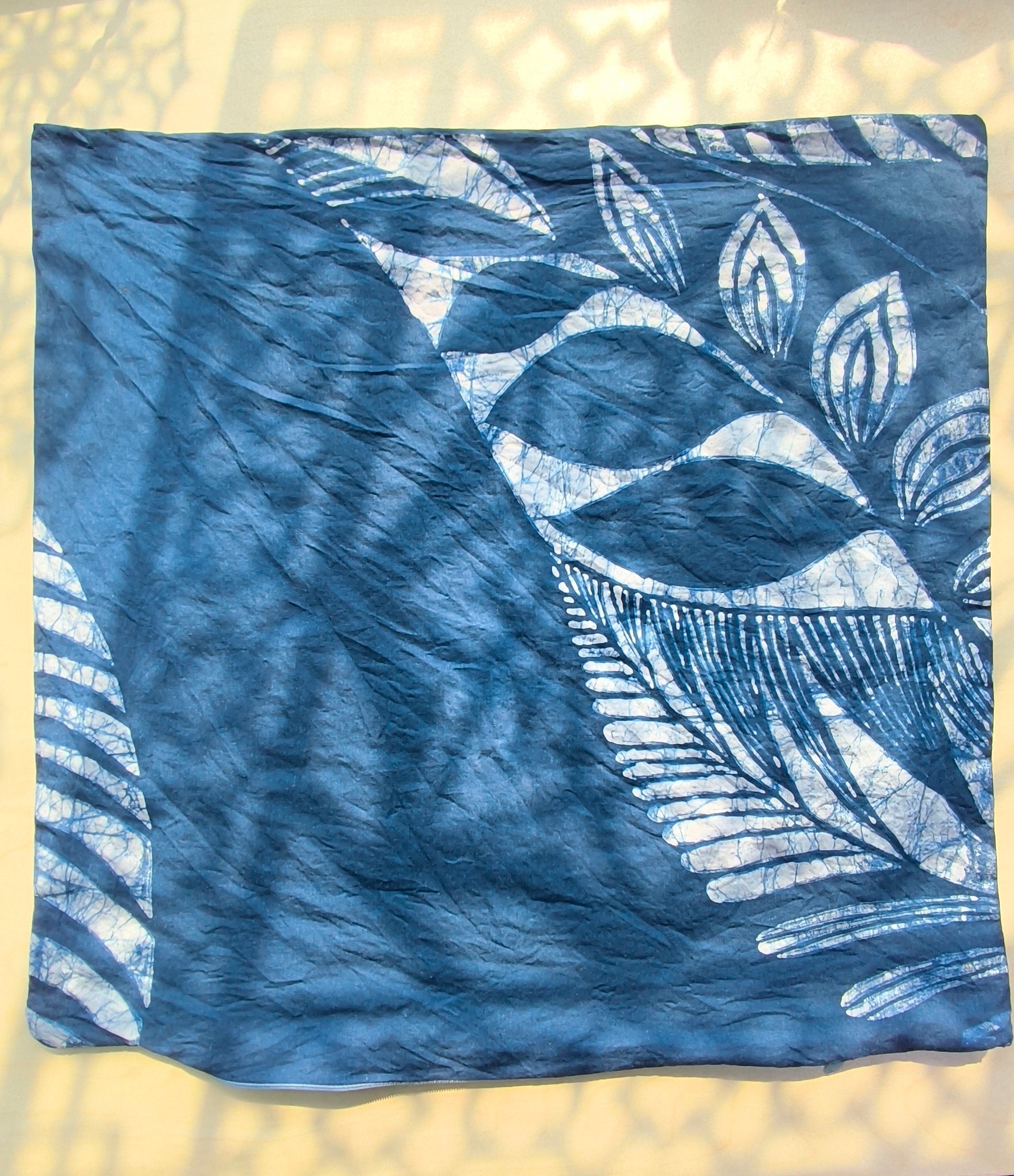 Blue fabric with white leaf pattern on a light background