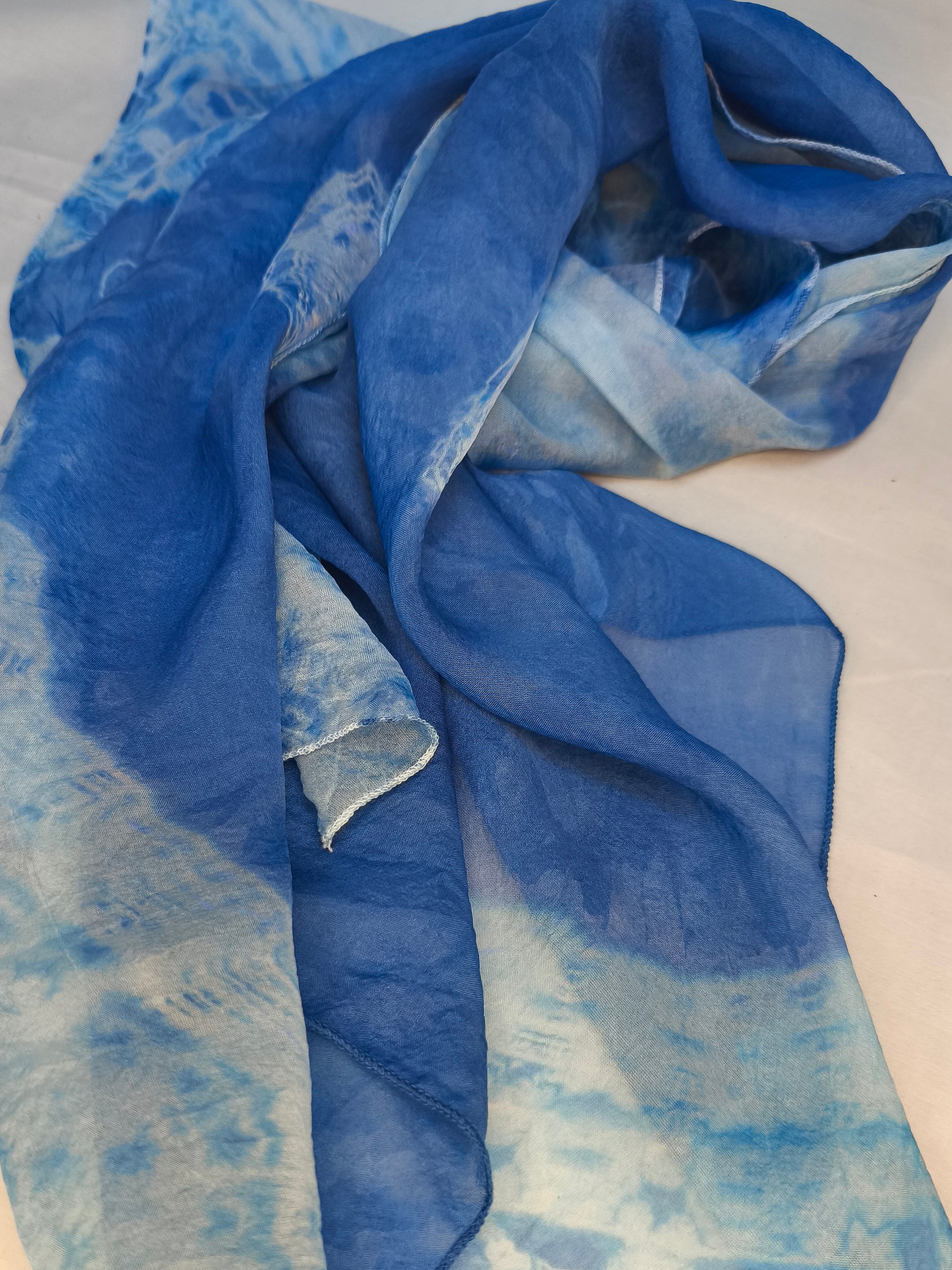 Blue scarf with watercolor design on a white background