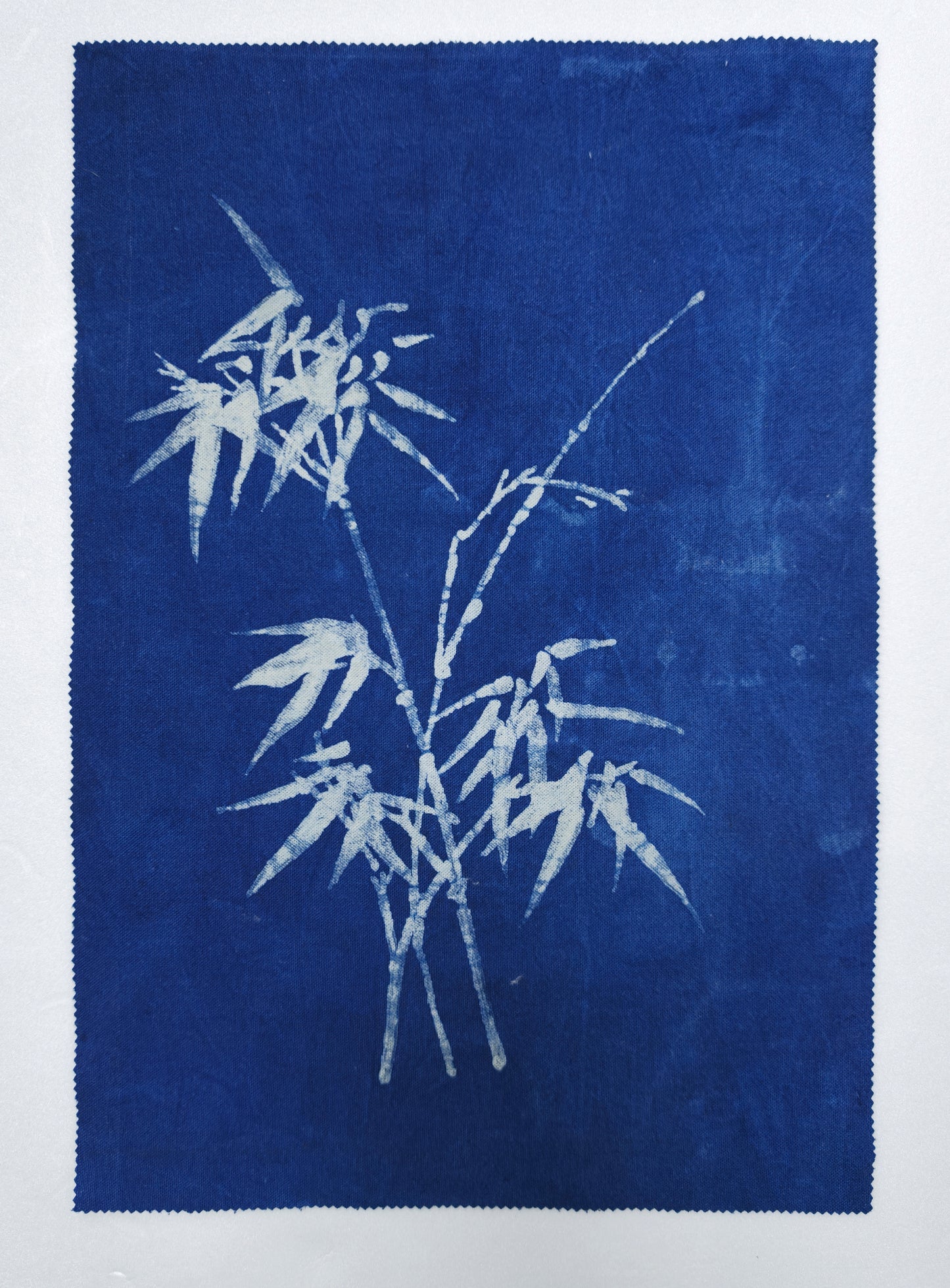 White bamboo leaves on a blue fabric background