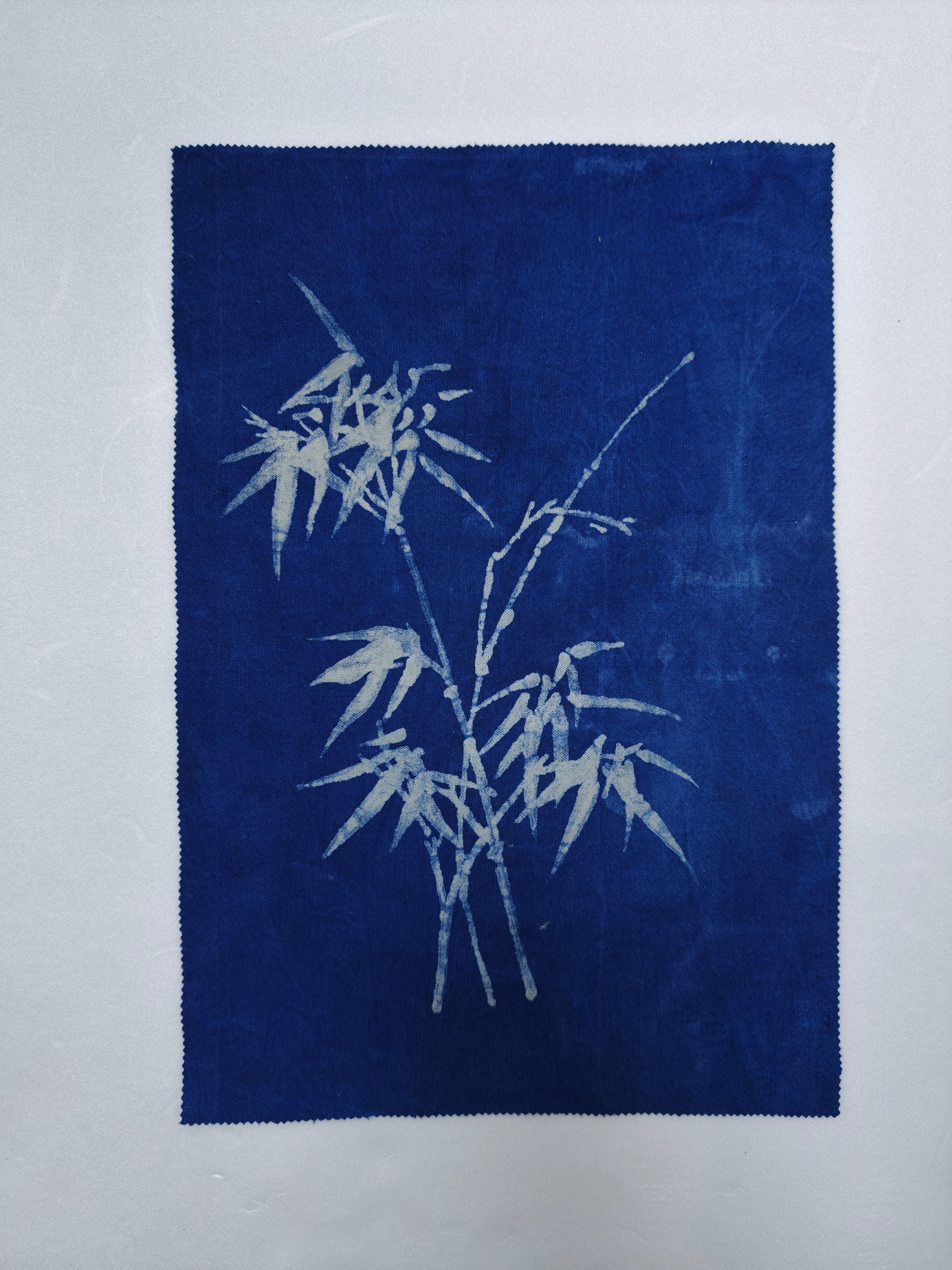 Blue fabric with white bamboo design on a light gray background