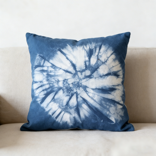 Blue tie-dye pillow on a beige couch