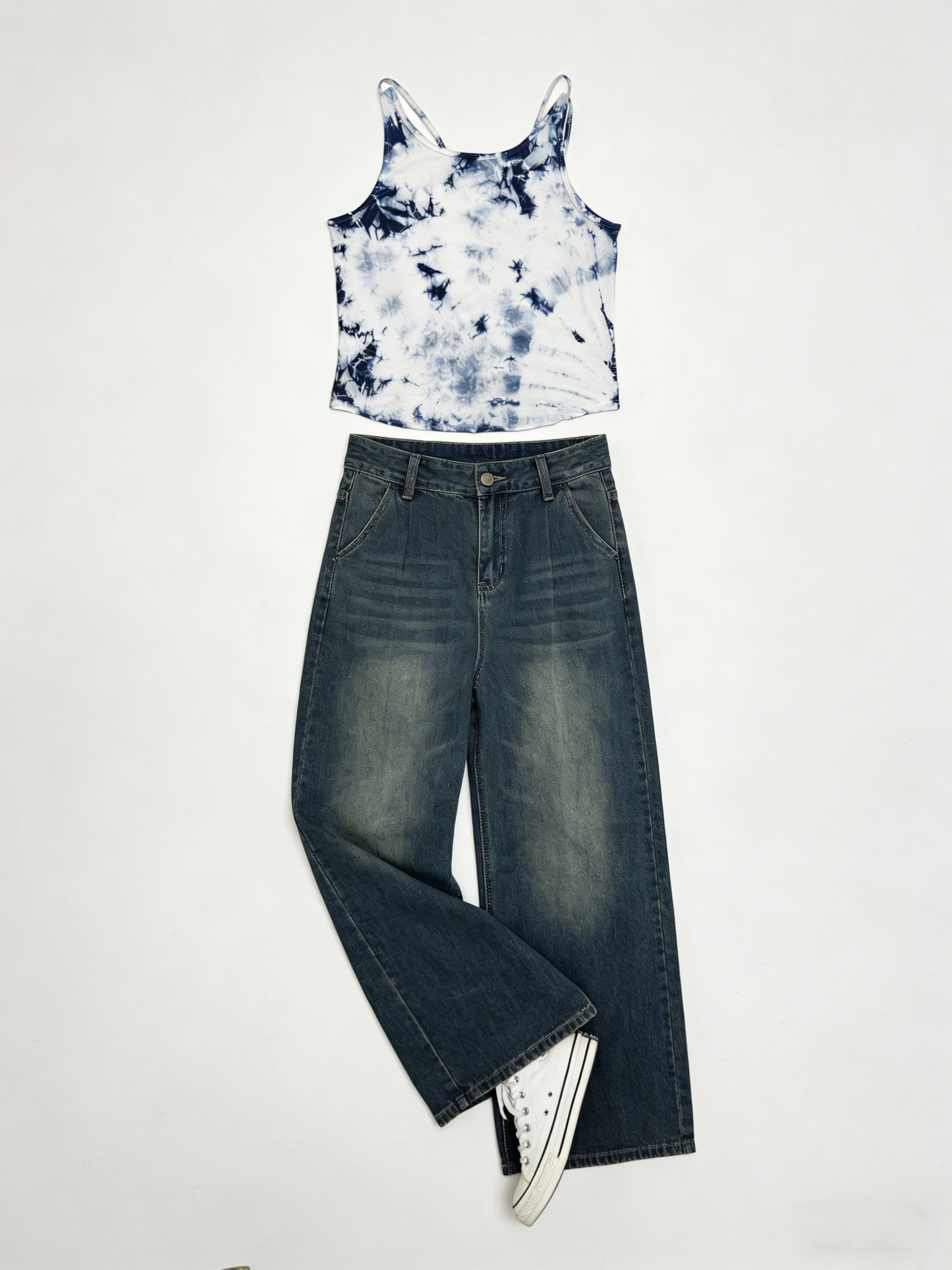 Tie-dye crop top and wide-leg jeans on a white background