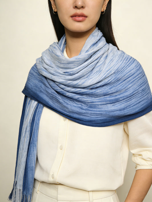 Person wearing a blue scarf on a plain background