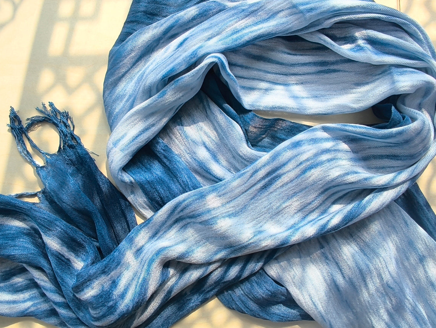 Blue and white striped scarf with tassels on a light background
