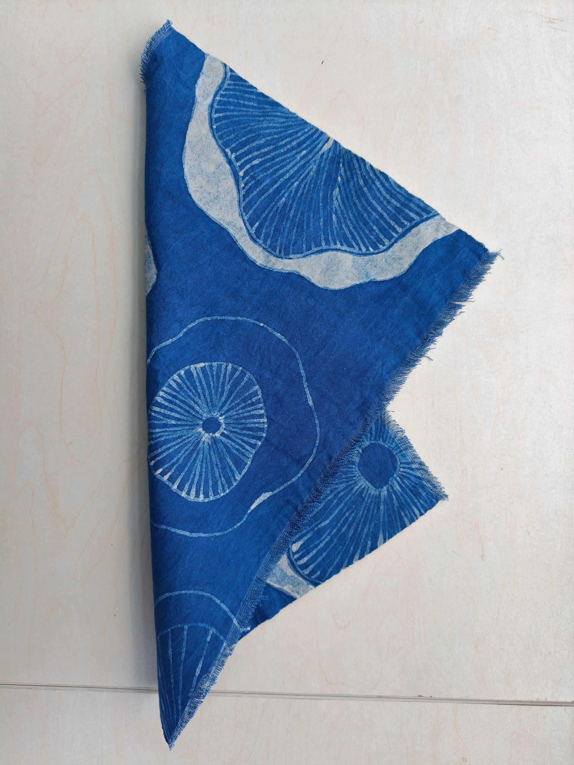 Blue fabric with white floral patterns on a light gray background