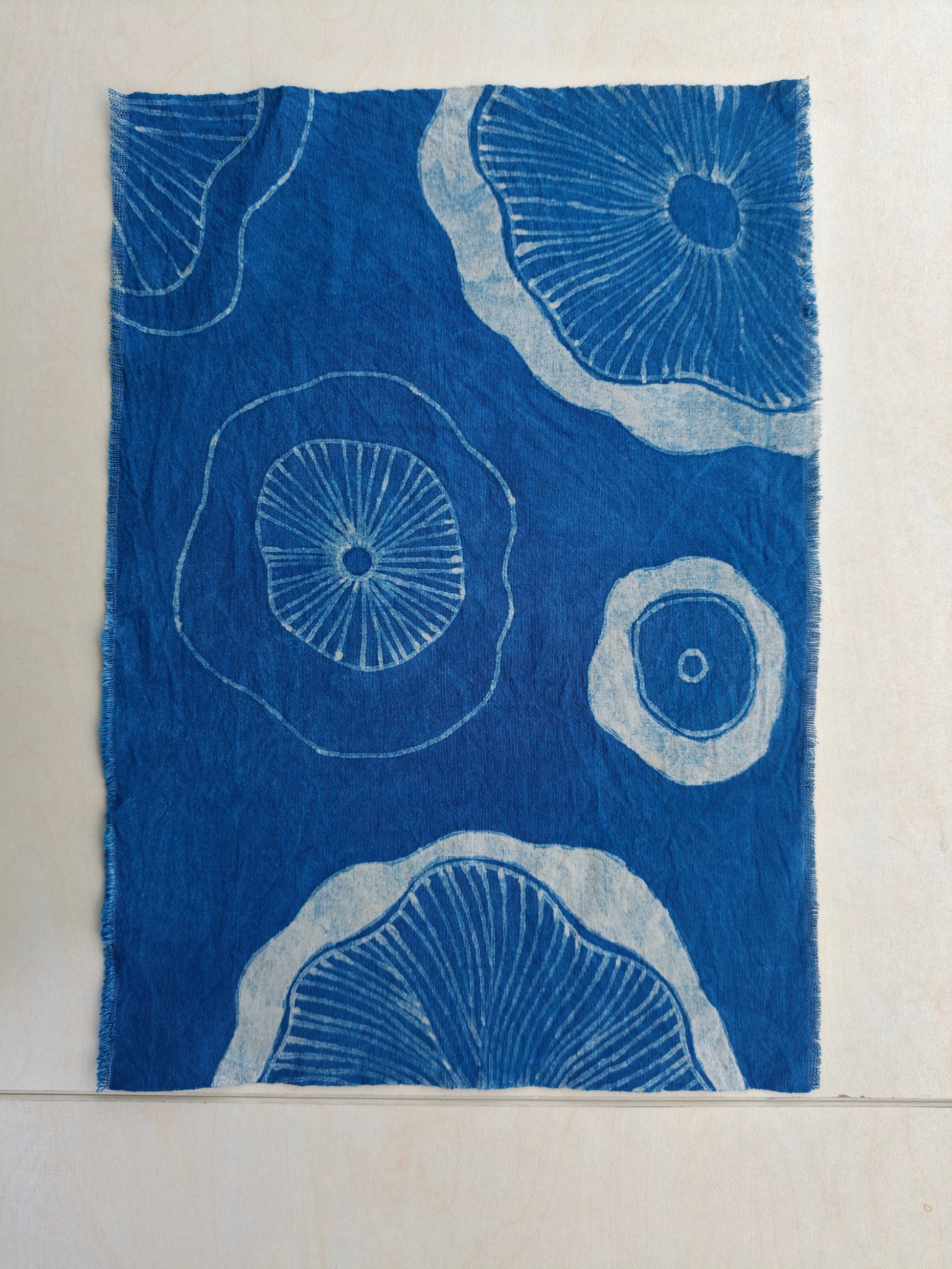 Blue fabric with white circular patterns on a beige background