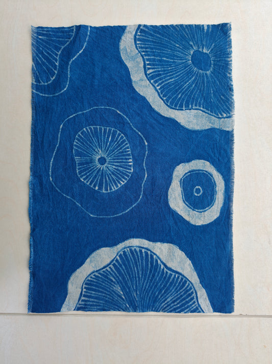 Blue fabric with white circular patterns on a beige background