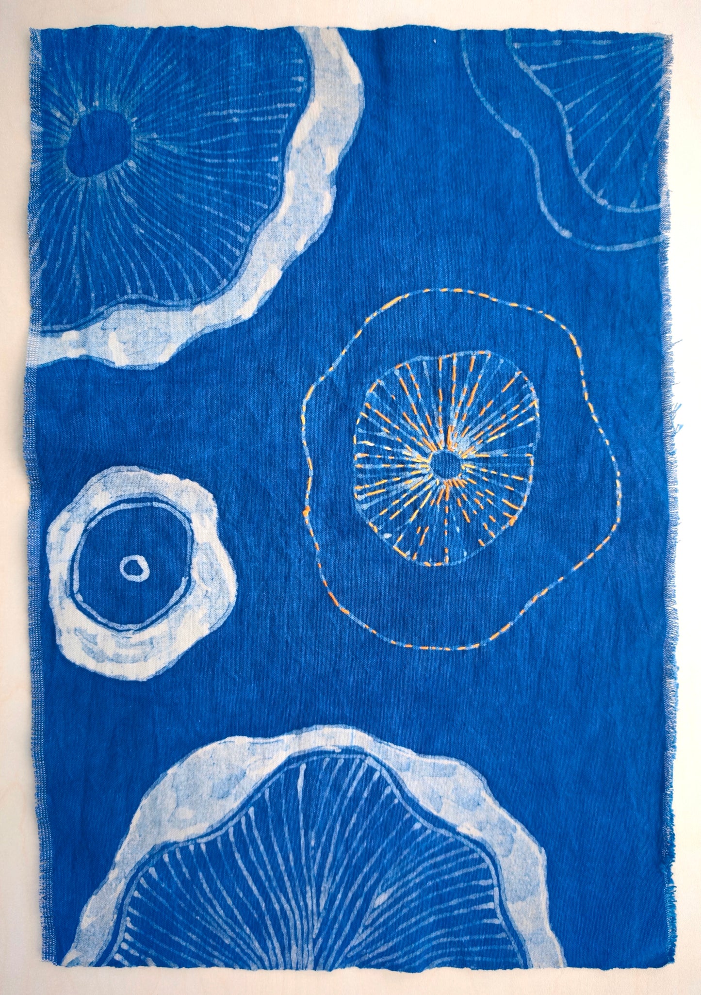 Blue fabric with white circular patterns on a beige background