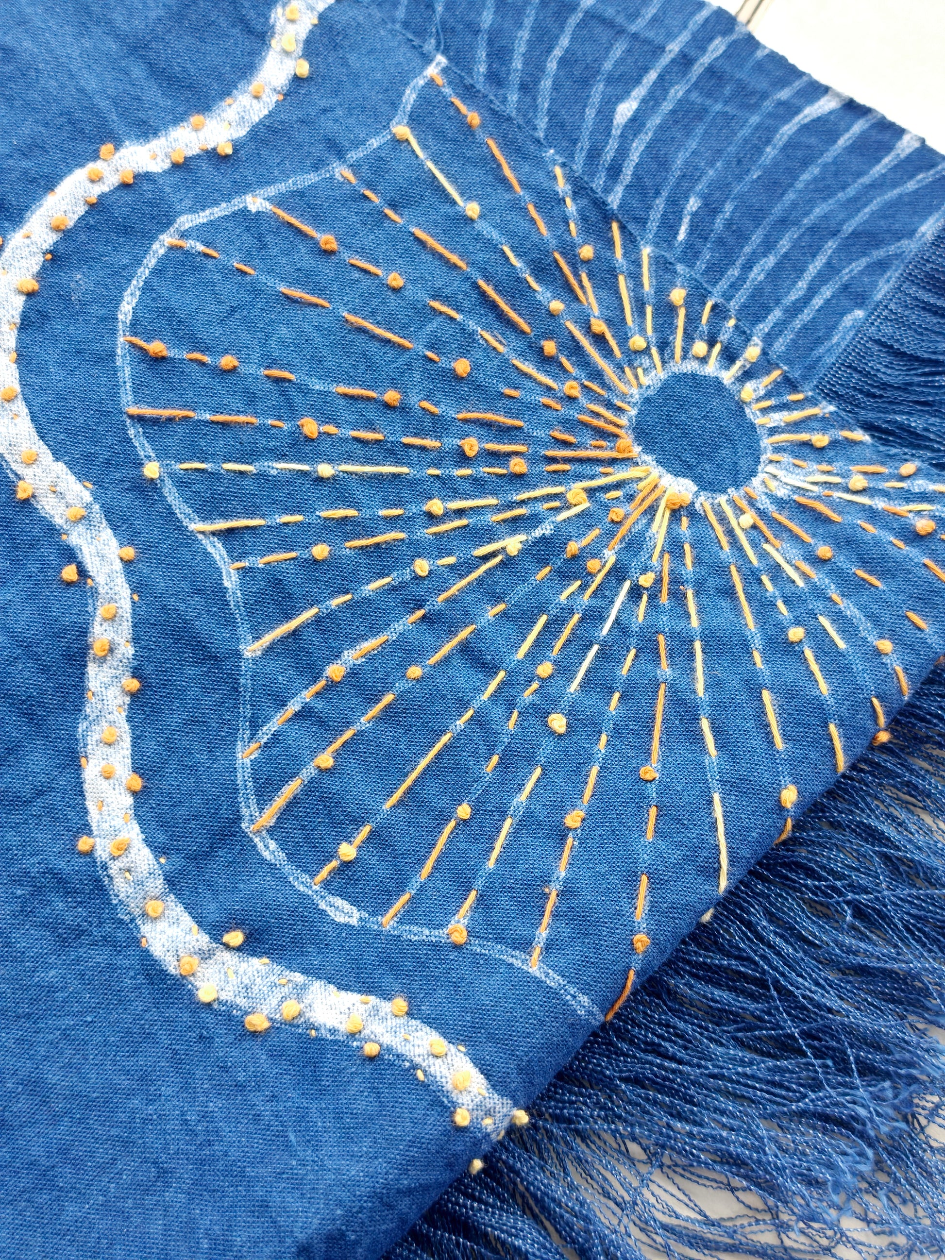 Blue fabric with gold embroidery and fringe details