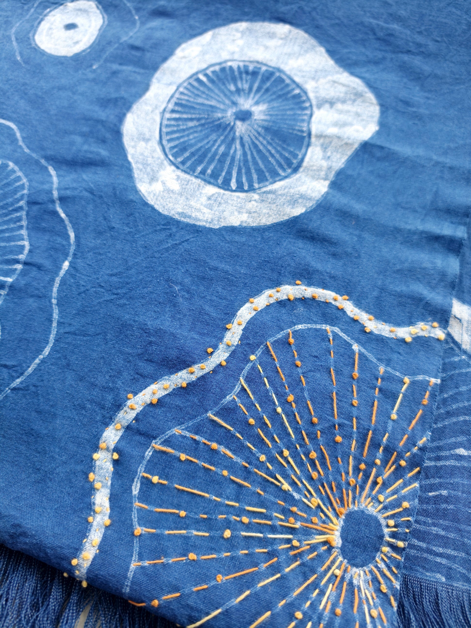 Textile with white and gold abstract patterns on a blue background