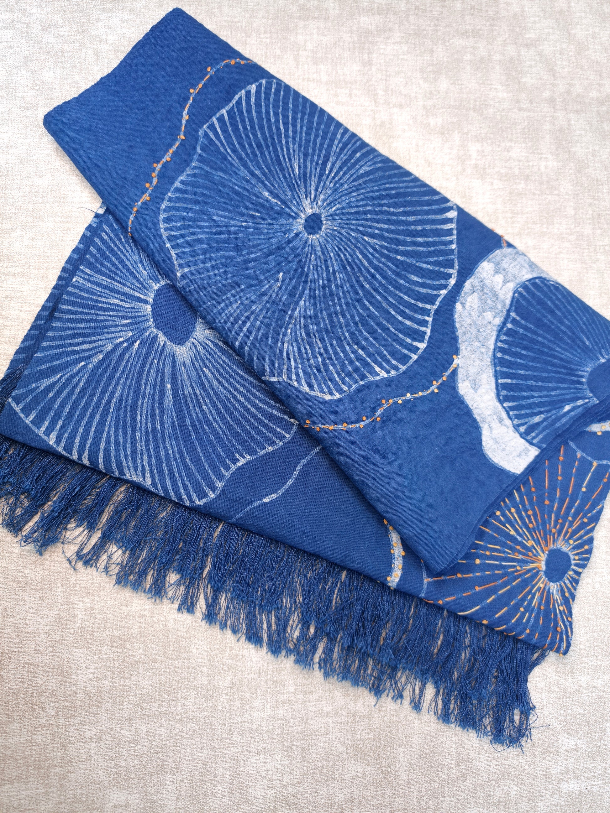 Blue scarf with white floral patterns on a light gray background