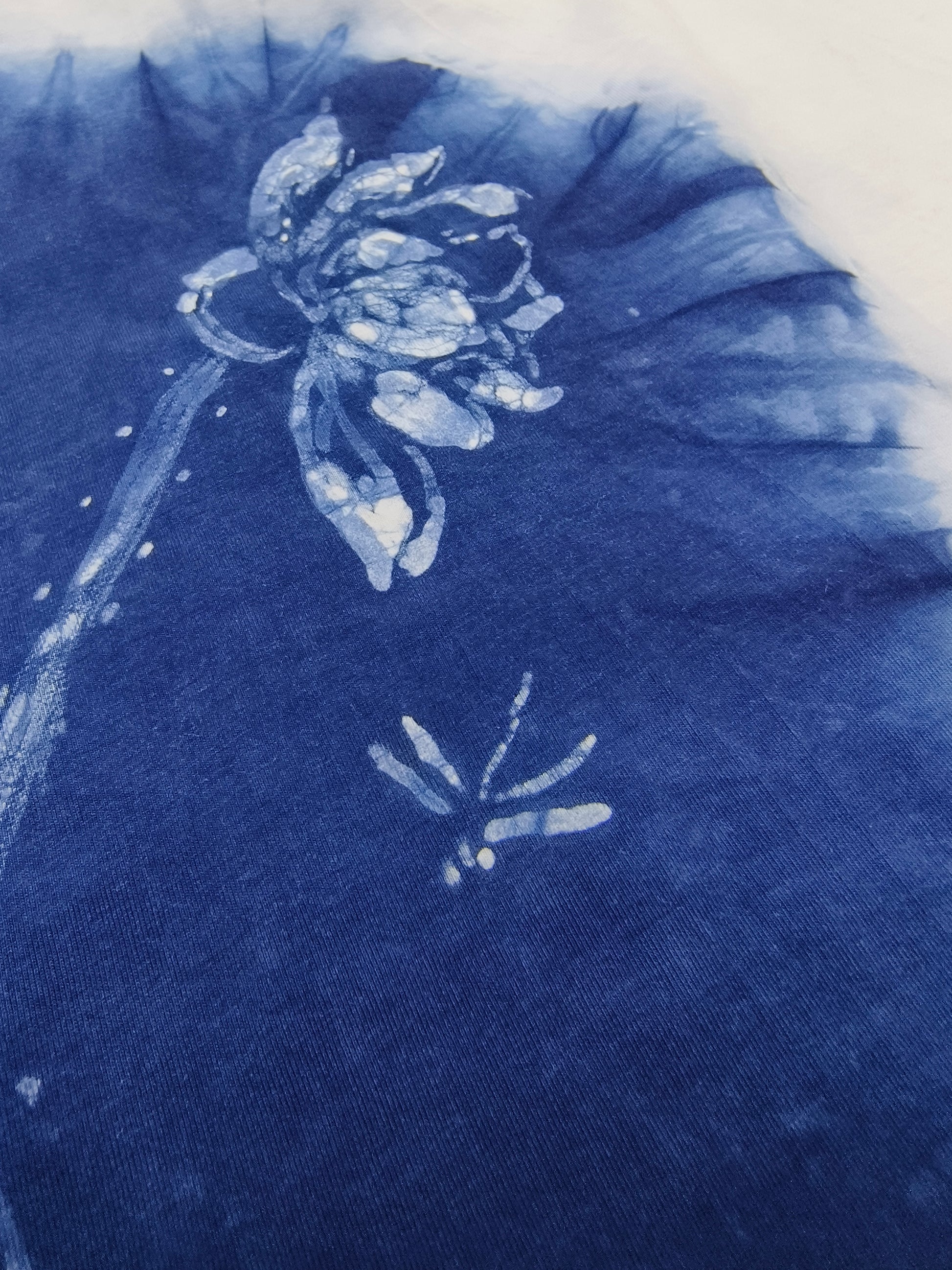 Blue fabric with white floral patterns, possibly from a textile or garment.