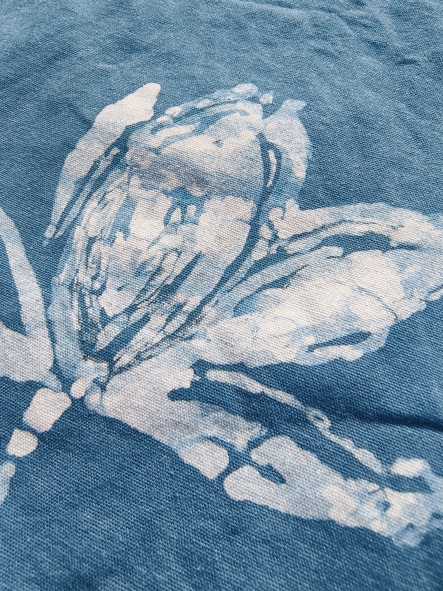 Close-up of a blue denim fabric with white stitching and patterns.