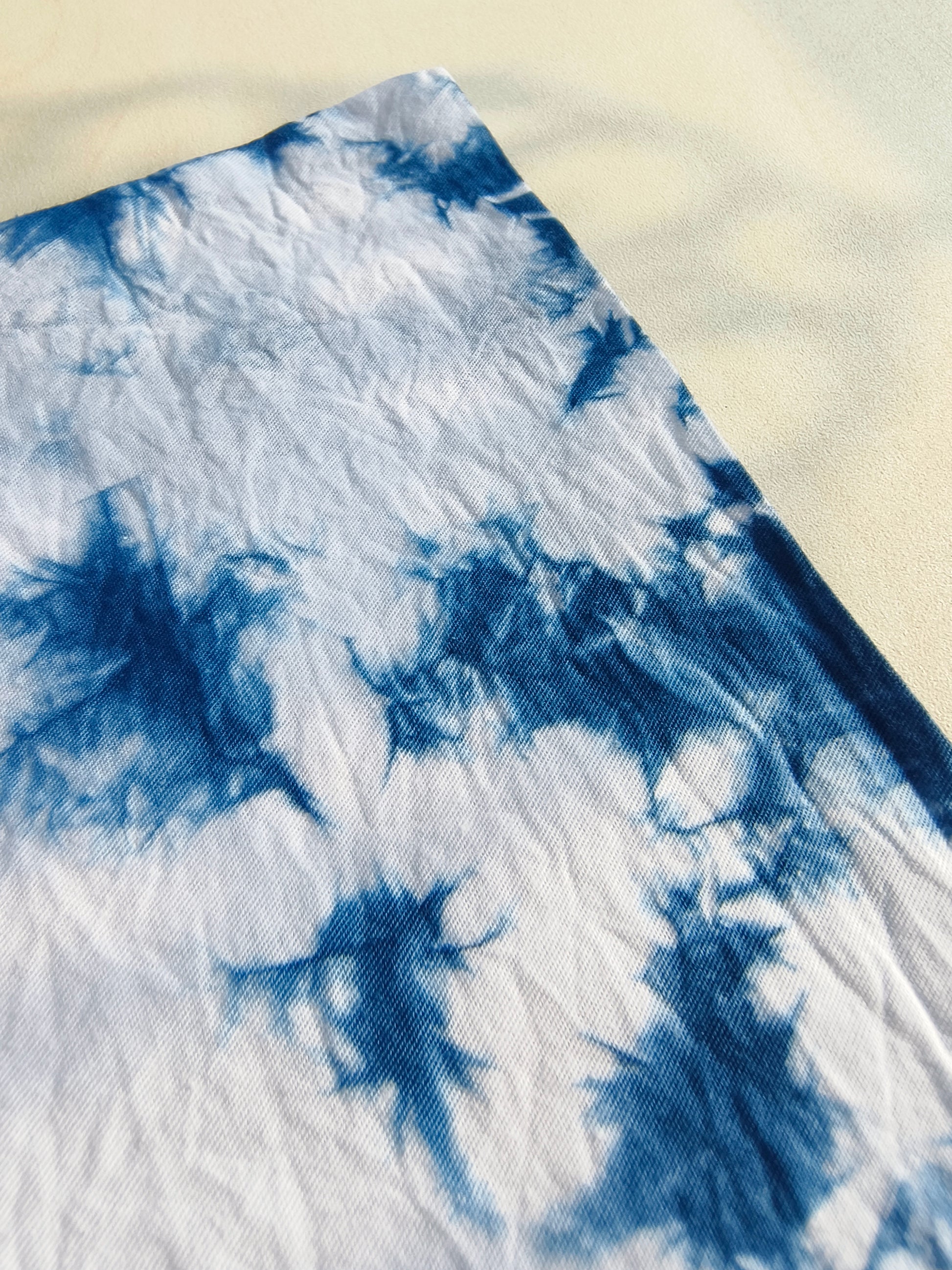 Blue and white tie-dye fabric on a beige surface