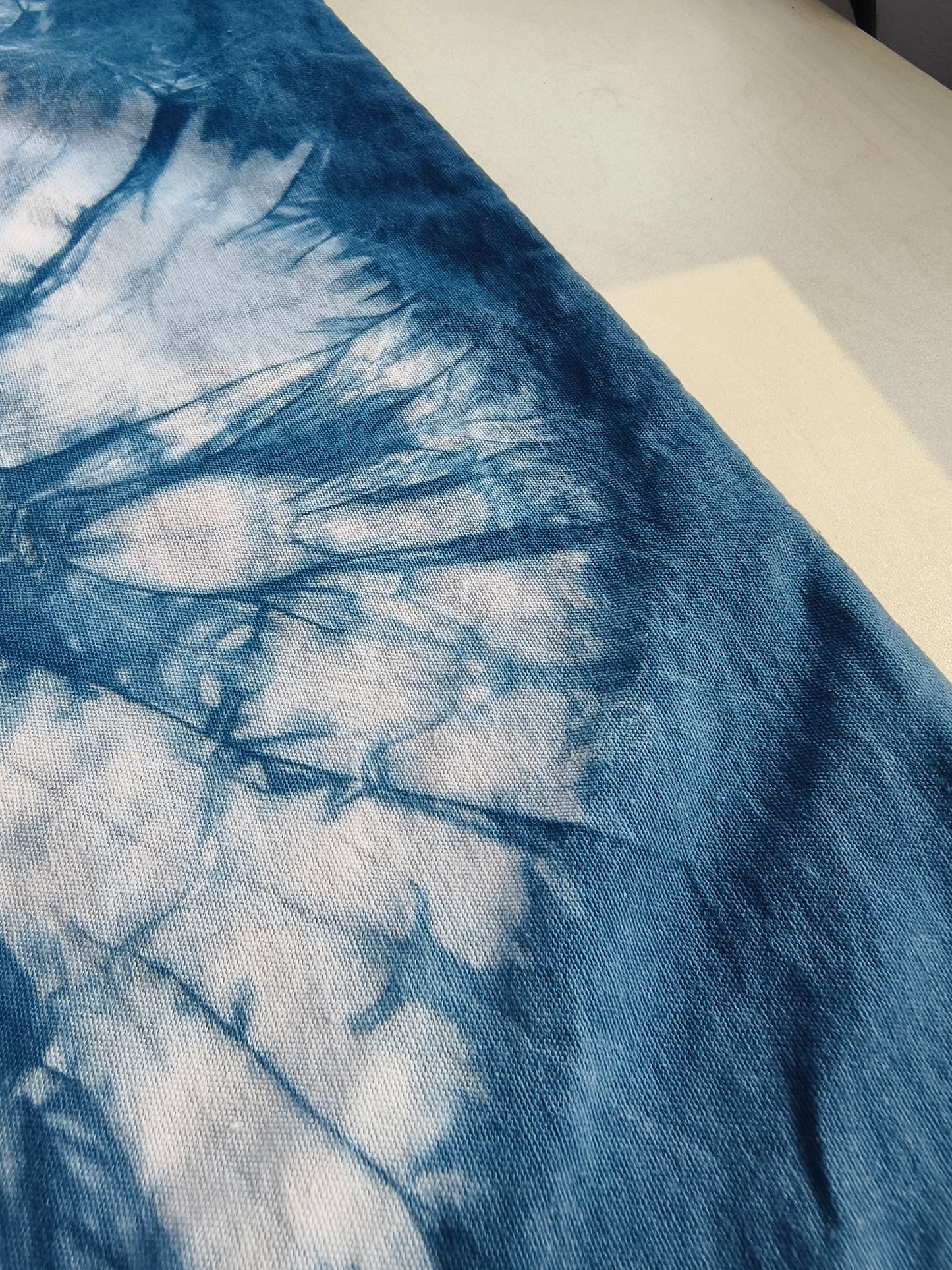 Close-up of a blue and white tie-dye fabric on a plain background