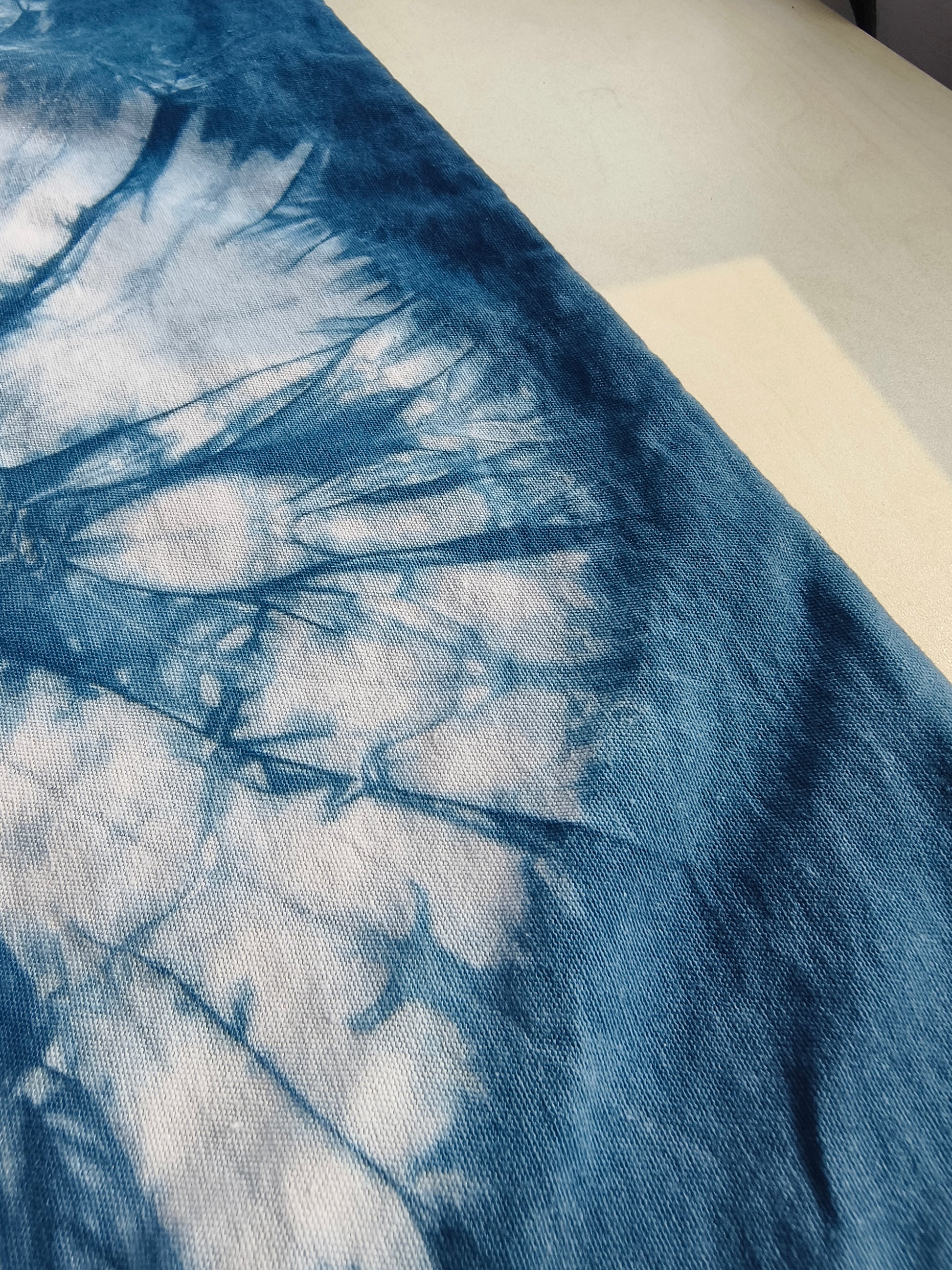 Close-up of a blue and white tie-dye fabric on a plain background