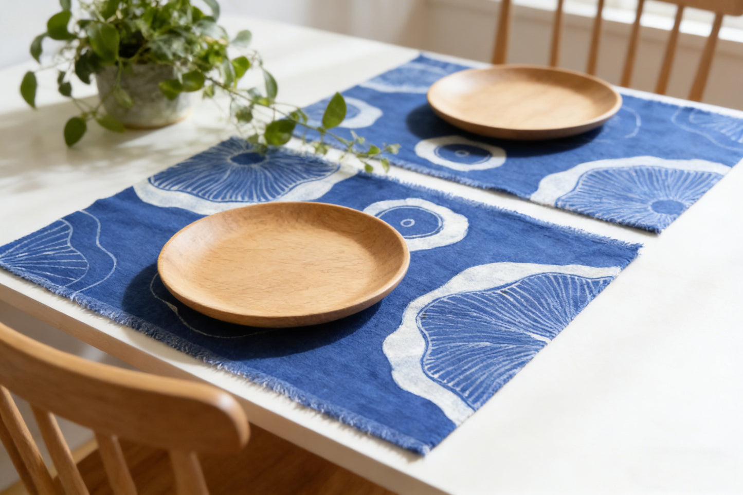Dining table with blue placemats and wooden plates